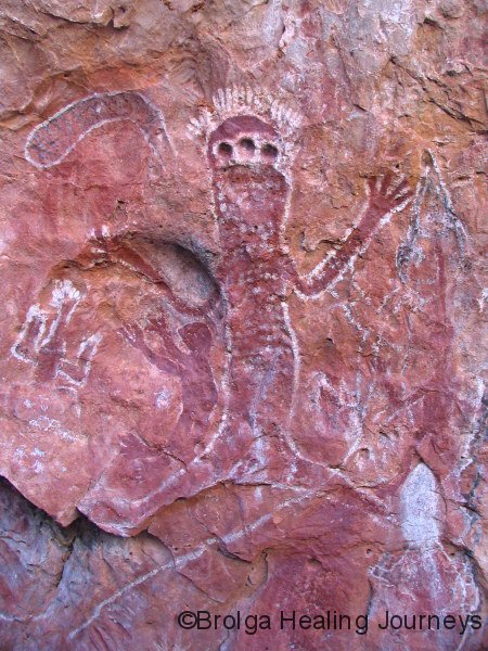 Gninglig Rock, Kimberley.  Wandjina figure combining ochre and petroglyphs (in this case cupules). 