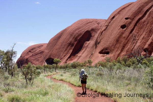 Nirbeeja walks beside the spectacular eastern face of Uluru